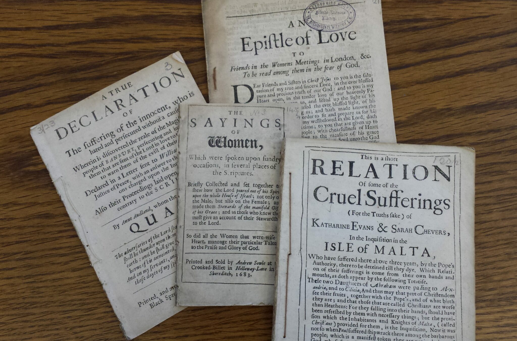 A collection of early quaker pamphlets by women on a wooden desk